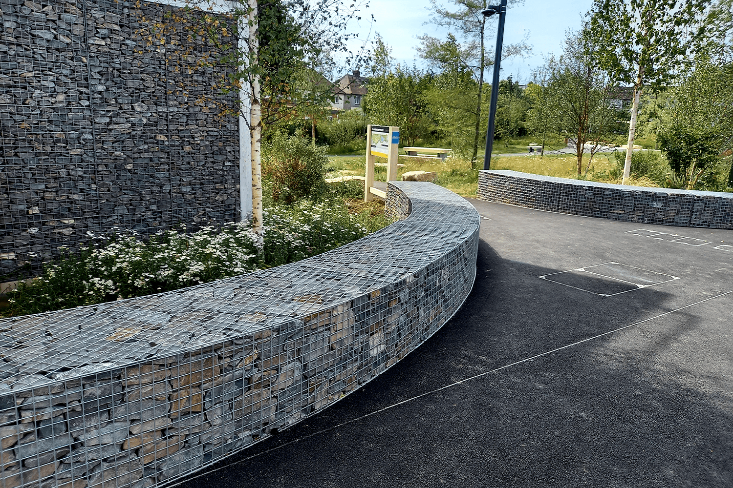 Gebogen schanskorf-keermuur in een groen park