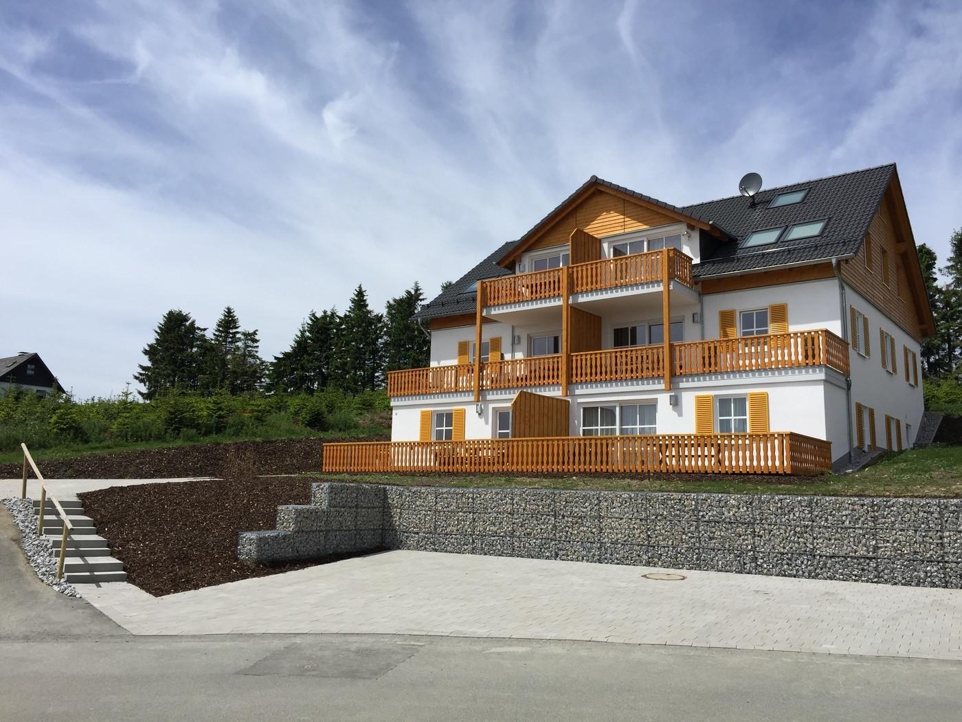 Vakantiewoning met schanskorf-keermuur op een helling