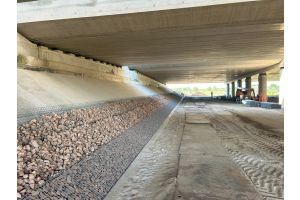 Grondkering met steenkorven onder een viaduct – Zakelijke toepassingen. Grondkering met steenkorven onder een viaduct