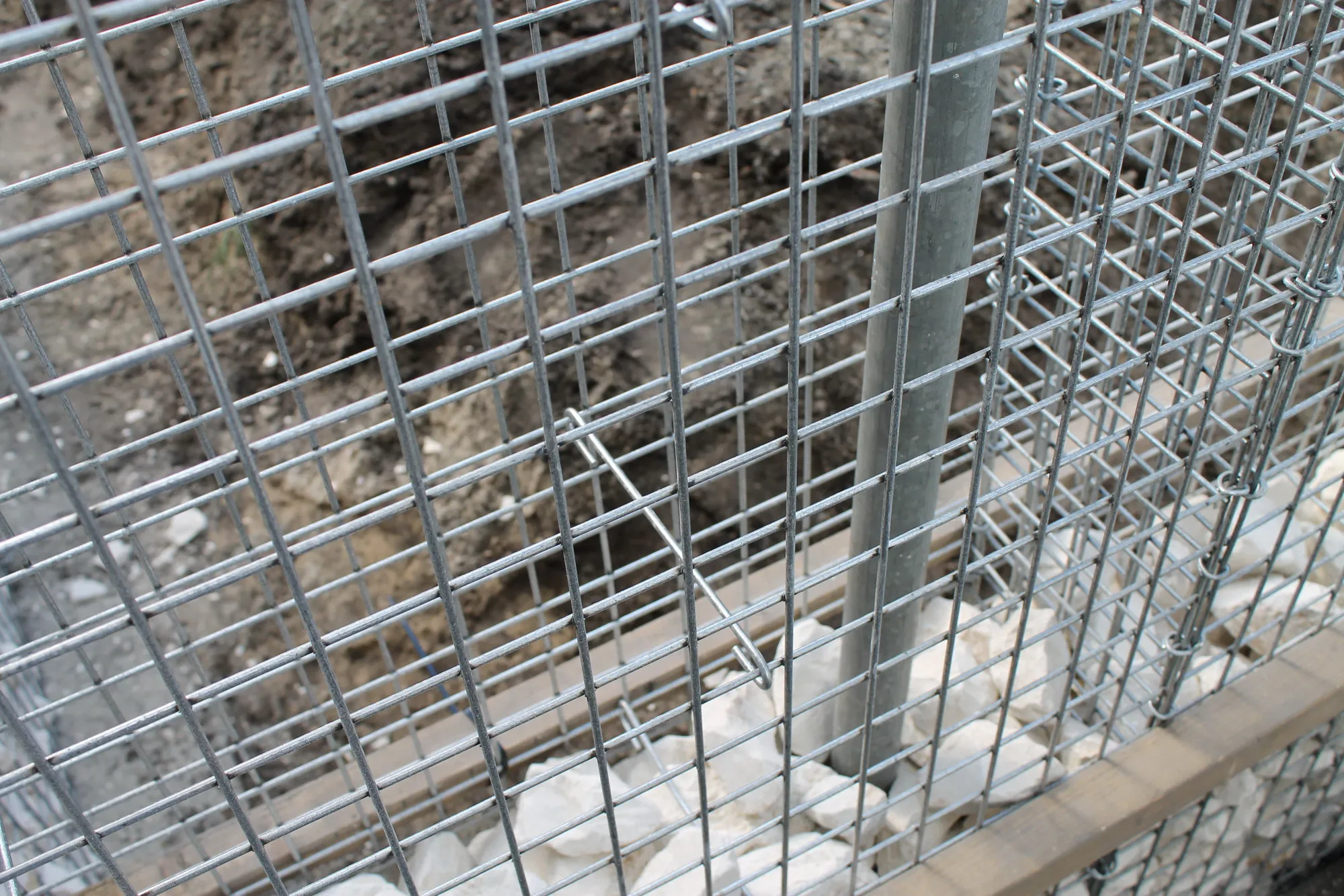 Afstandhouders in de schanskorven plaatsen